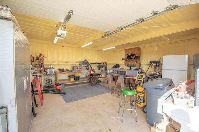 garage featuring white fridge and a garage door opener