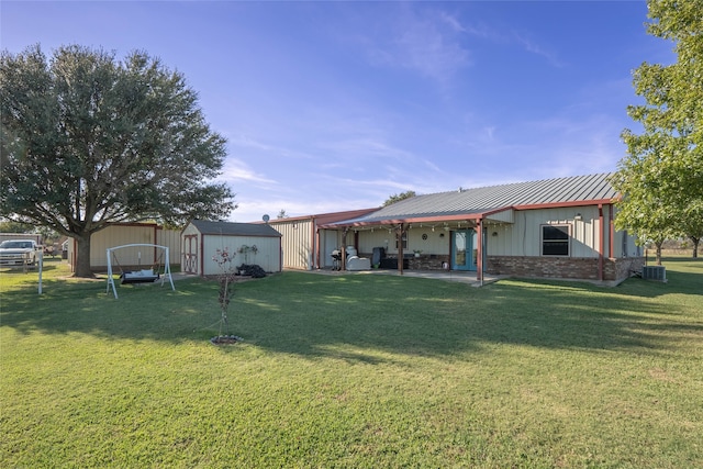 rear view of house featuring a lawn and a storage shed