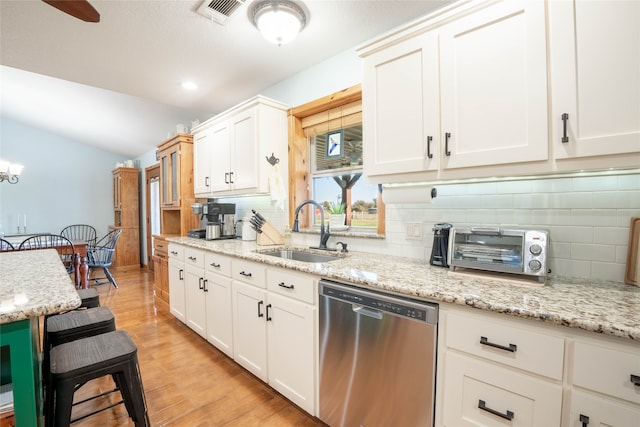 kitchen featuring decorative backsplash, sink, light hardwood / wood-style flooring, dishwasher, and white cabinetry