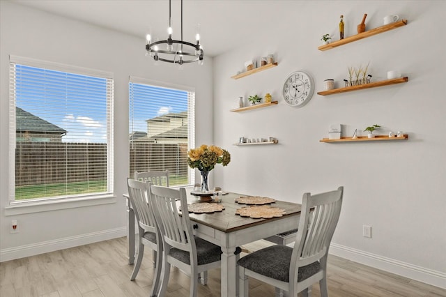 dining room with a notable chandelier, plenty of natural light, and light hardwood / wood-style flooring