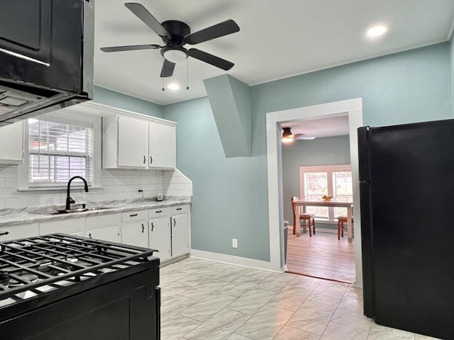 kitchen with black appliances, sink, ceiling fan, tasteful backsplash, and white cabinetry