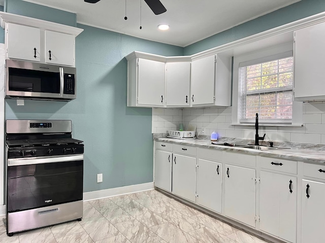 kitchen with appliances with stainless steel finishes, white cabinetry, and sink