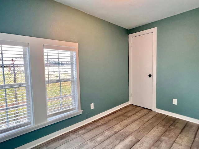 empty room with wood-type flooring and a wealth of natural light