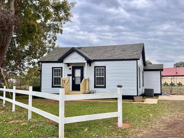 view of front of property with central AC unit and a front yard