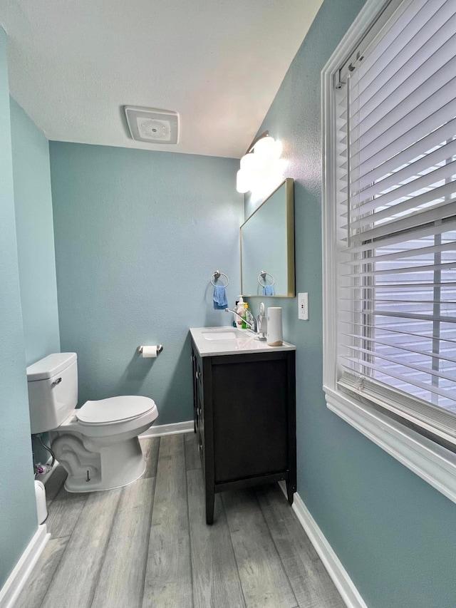 bathroom with hardwood / wood-style floors, vanity, and toilet