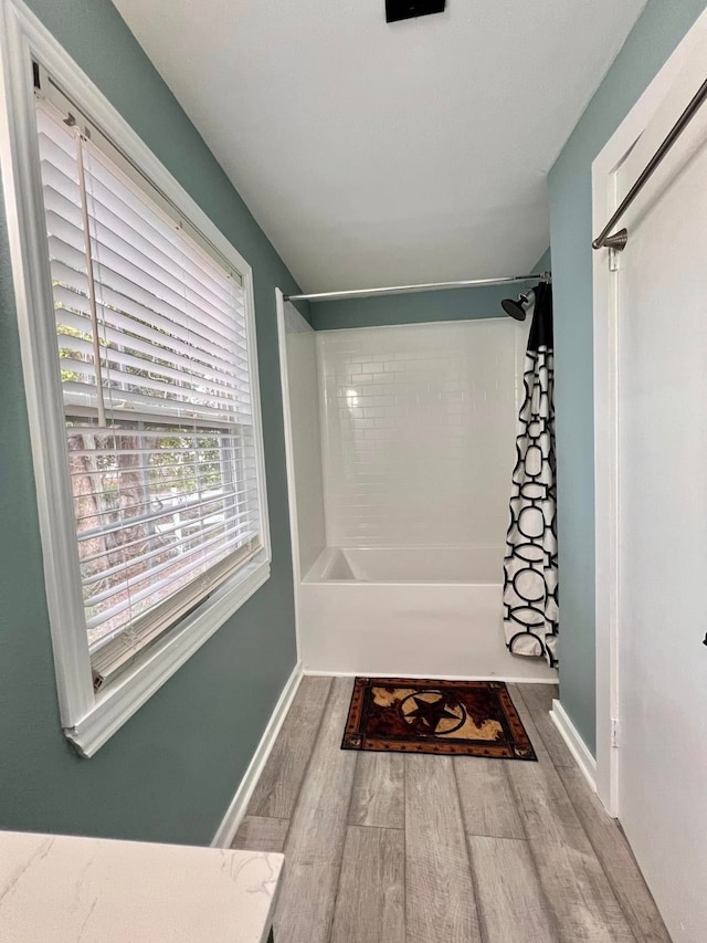 bathroom with hardwood / wood-style floors and tiled shower / bath combo