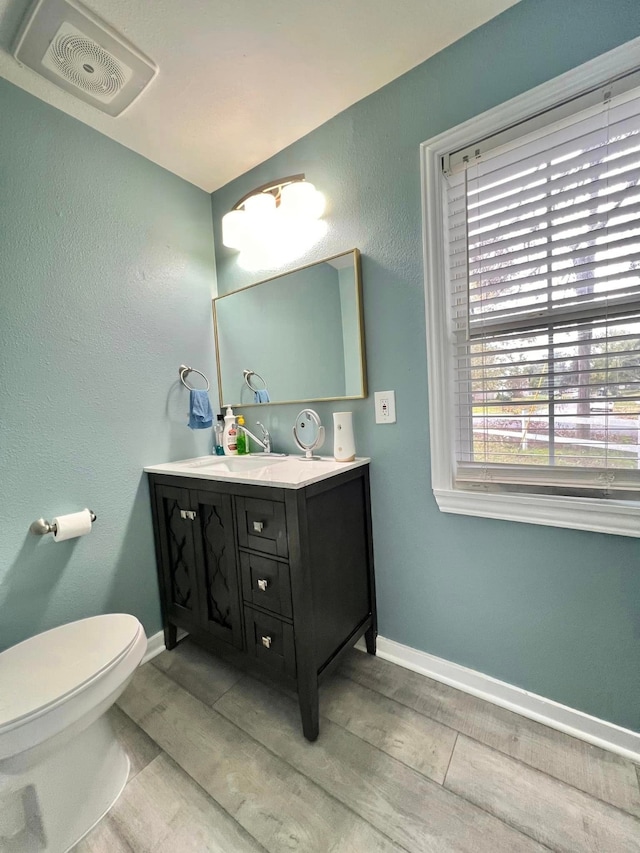 bathroom with wood-type flooring, vanity, and toilet