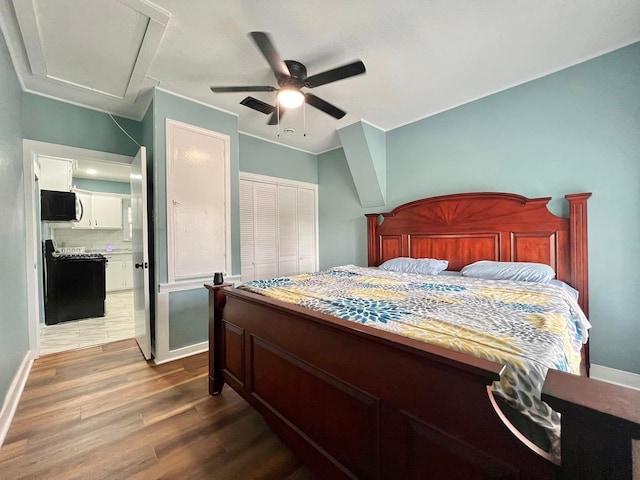 bedroom with wood-type flooring, a closet, ceiling fan, and ensuite bathroom