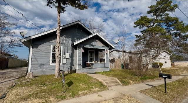 bungalow with a front yard and covered porch