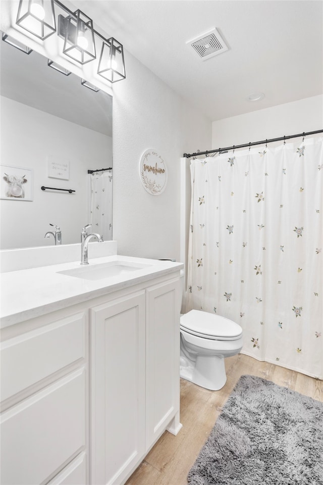 bathroom with hardwood / wood-style flooring, vanity, and toilet