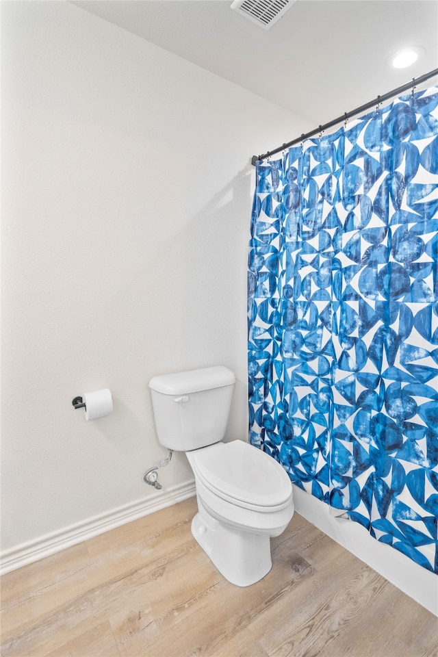 bathroom featuring a shower with shower curtain, wood-type flooring, and toilet