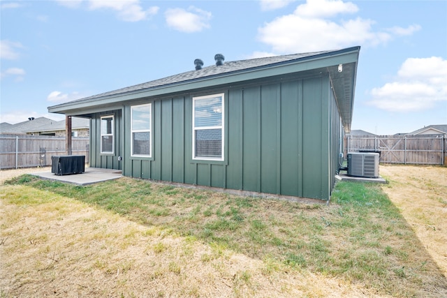 back of property with a lawn, a patio area, and central AC unit