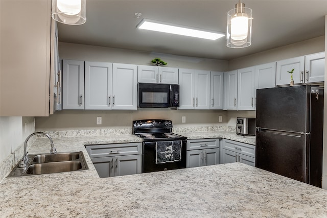 kitchen with black appliances, sink, and hanging light fixtures