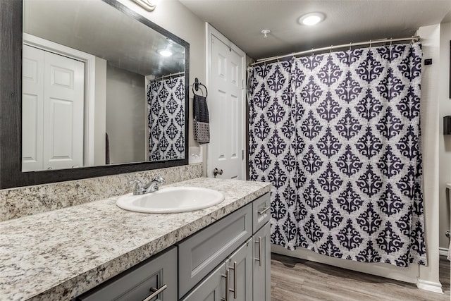 bathroom featuring a shower with curtain, vanity, wood-type flooring, and a textured ceiling