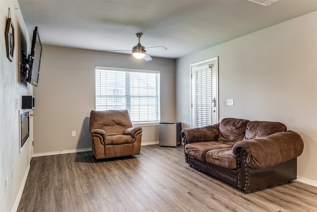 living room featuring light hardwood / wood-style flooring and ceiling fan