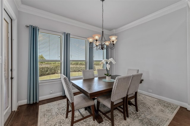 dining space featuring crown molding, dark wood-type flooring, and an inviting chandelier