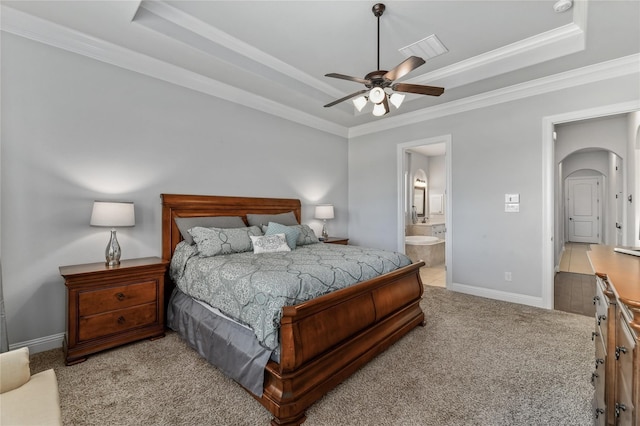 carpeted bedroom featuring connected bathroom, a raised ceiling, ceiling fan, and crown molding