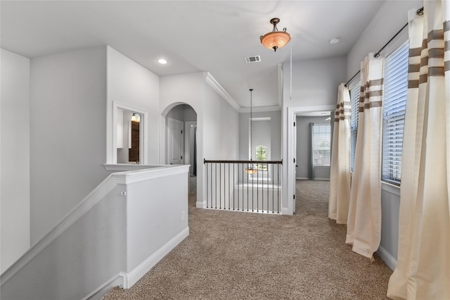 hall with carpet flooring and ornamental molding