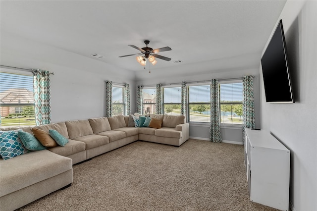 living room featuring light carpet, ceiling fan, and a healthy amount of sunlight