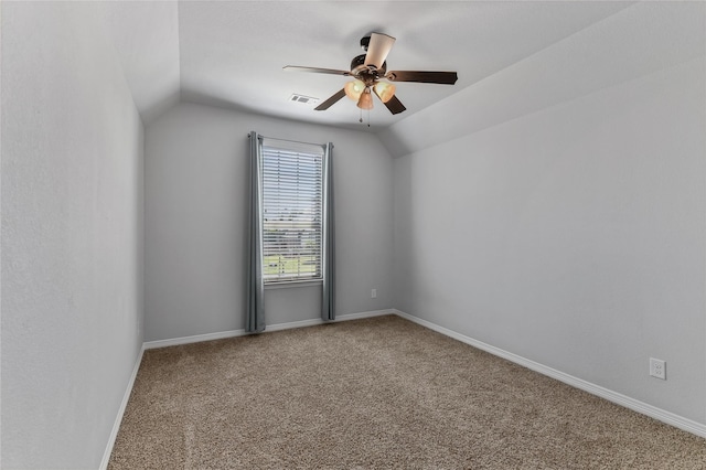 carpeted spare room featuring ceiling fan and vaulted ceiling