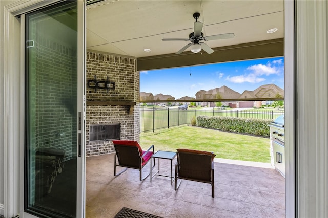 view of patio / terrace with an outdoor brick fireplace and ceiling fan