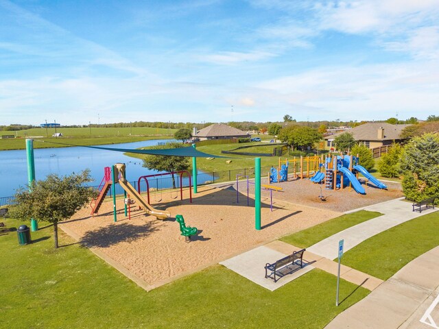 view of playground with a lawn and a water view