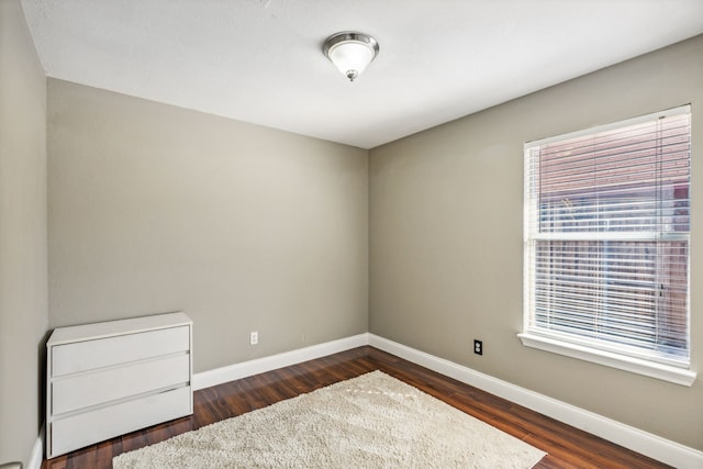 unfurnished room with dark hardwood / wood-style flooring