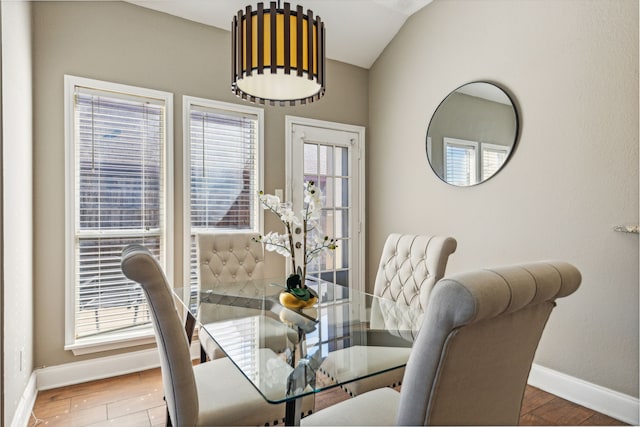 dining room with hardwood / wood-style floors and vaulted ceiling