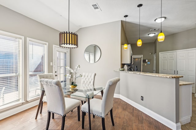 dining area featuring lofted ceiling and wood-type flooring