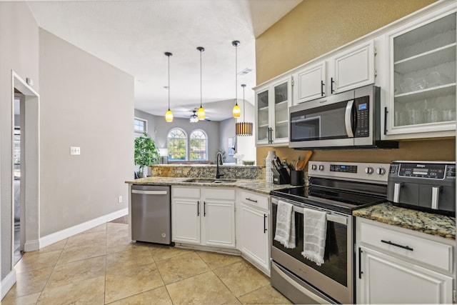 kitchen featuring decorative light fixtures, sink, stainless steel appliances, and white cabinetry