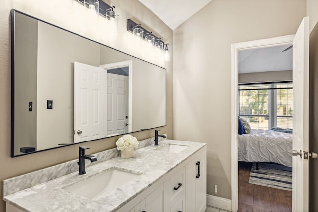 bathroom featuring vaulted ceiling, hardwood / wood-style flooring, and vanity