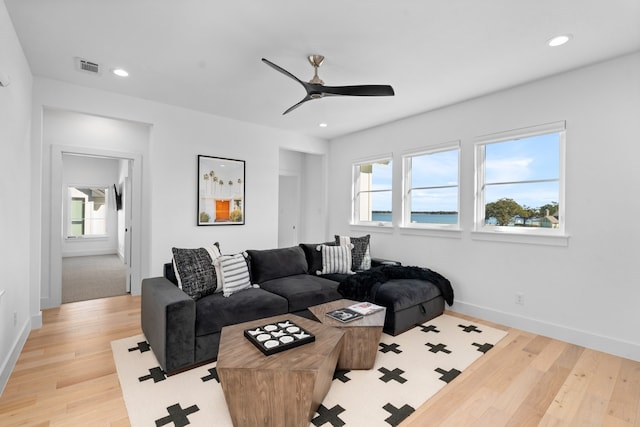 living room with ceiling fan and light hardwood / wood-style flooring