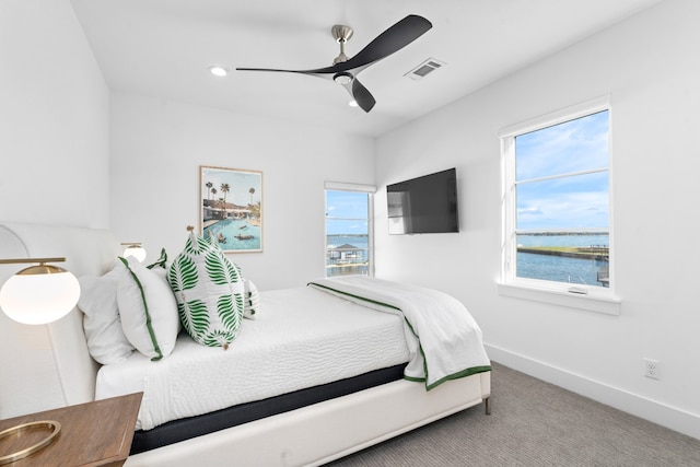 carpeted bedroom with multiple windows and ceiling fan