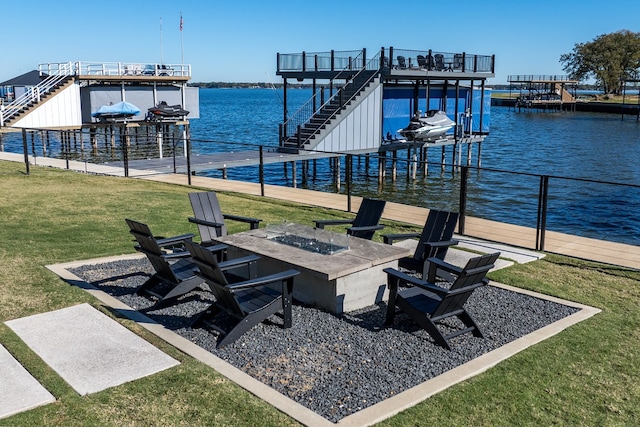 dock area with a yard, a water view, and an outdoor fire pit