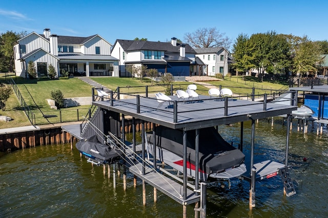 view of dock with a lawn and a water view