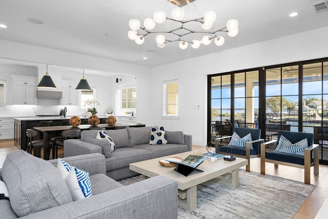 living room featuring a chandelier and light wood-type flooring