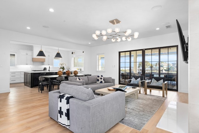 living room with a chandelier and light hardwood / wood-style floors