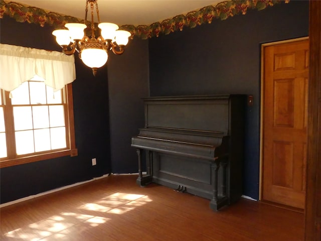 misc room with wood-type flooring and a notable chandelier