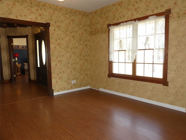 empty room with dark hardwood / wood-style flooring