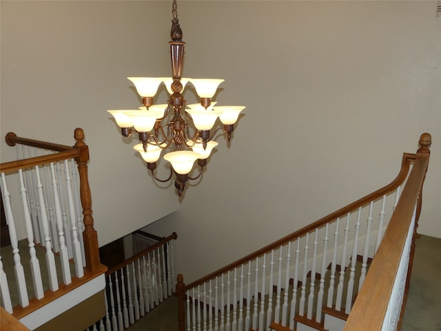 staircase featuring a chandelier