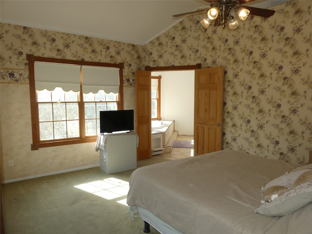 bedroom featuring ceiling fan, light colored carpet, connected bathroom, and vaulted ceiling