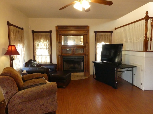 living room featuring ceiling fan and dark hardwood / wood-style flooring