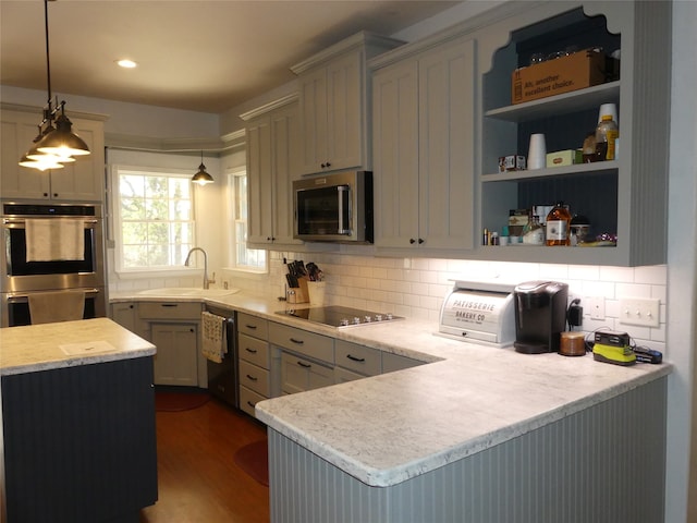 kitchen with sink, kitchen peninsula, decorative light fixtures, decorative backsplash, and appliances with stainless steel finishes