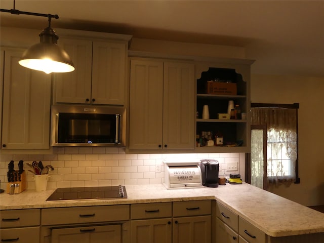 kitchen with backsplash, black electric stovetop, and pendant lighting