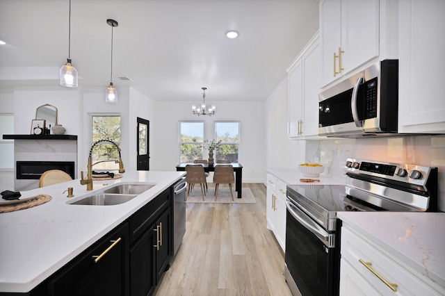 kitchen with sink, white cabinets, pendant lighting, and appliances with stainless steel finishes