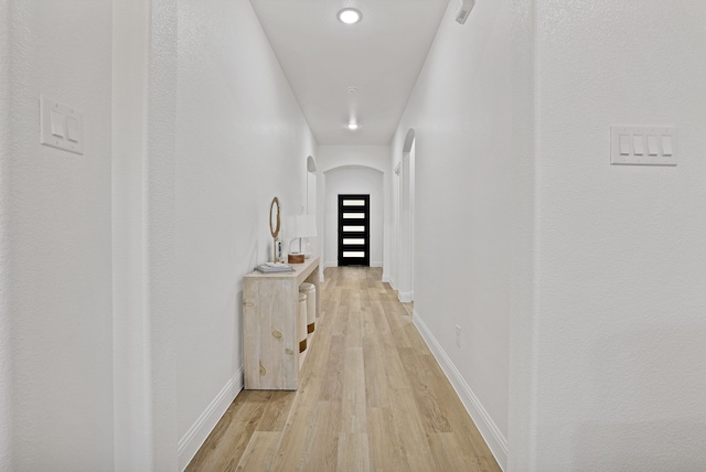 hallway with light hardwood / wood-style floors