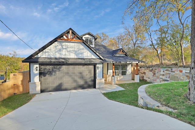 view of front of house featuring a front yard, a porch, and a garage