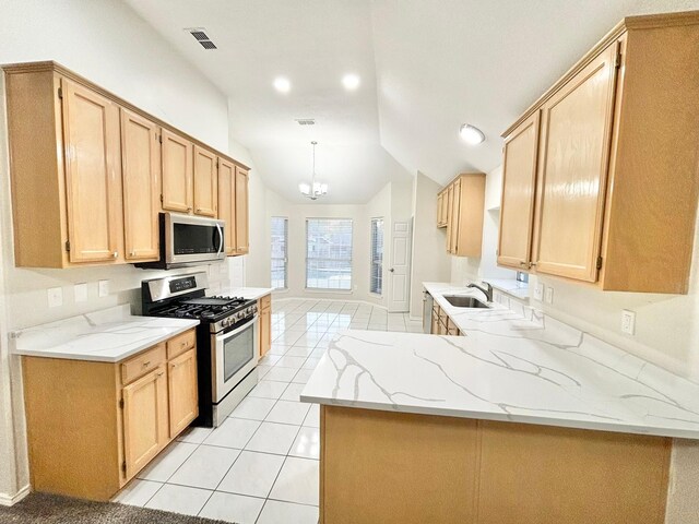 kitchen with light brown cabinets, sink, stainless steel appliances, and vaulted ceiling