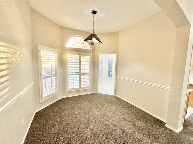 unfurnished room featuring carpet flooring and vaulted ceiling