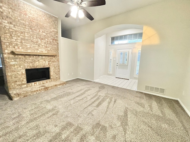 unfurnished living room with ceiling fan, a fireplace, and carpet floors